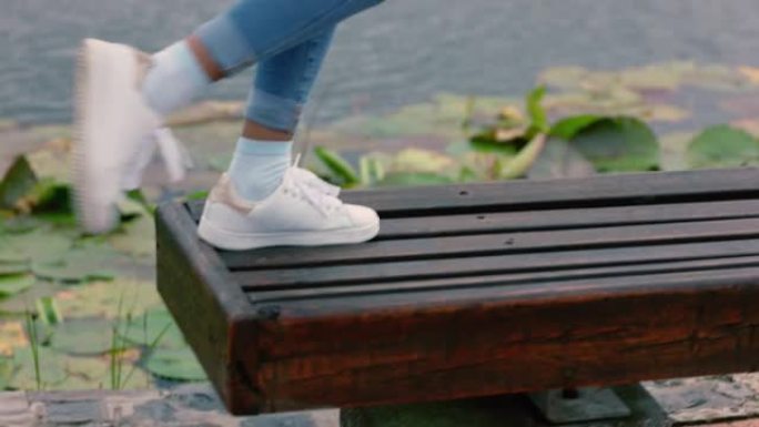 特写女人腿在公园散步跳上长凳享受户外嬉戏乐趣快乐少女穿着白鞋