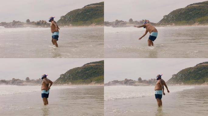有趣的非洲裔美国男子穿着鳍状肢在海水中走在海滩上准备游泳，享受海洋4k的夏天