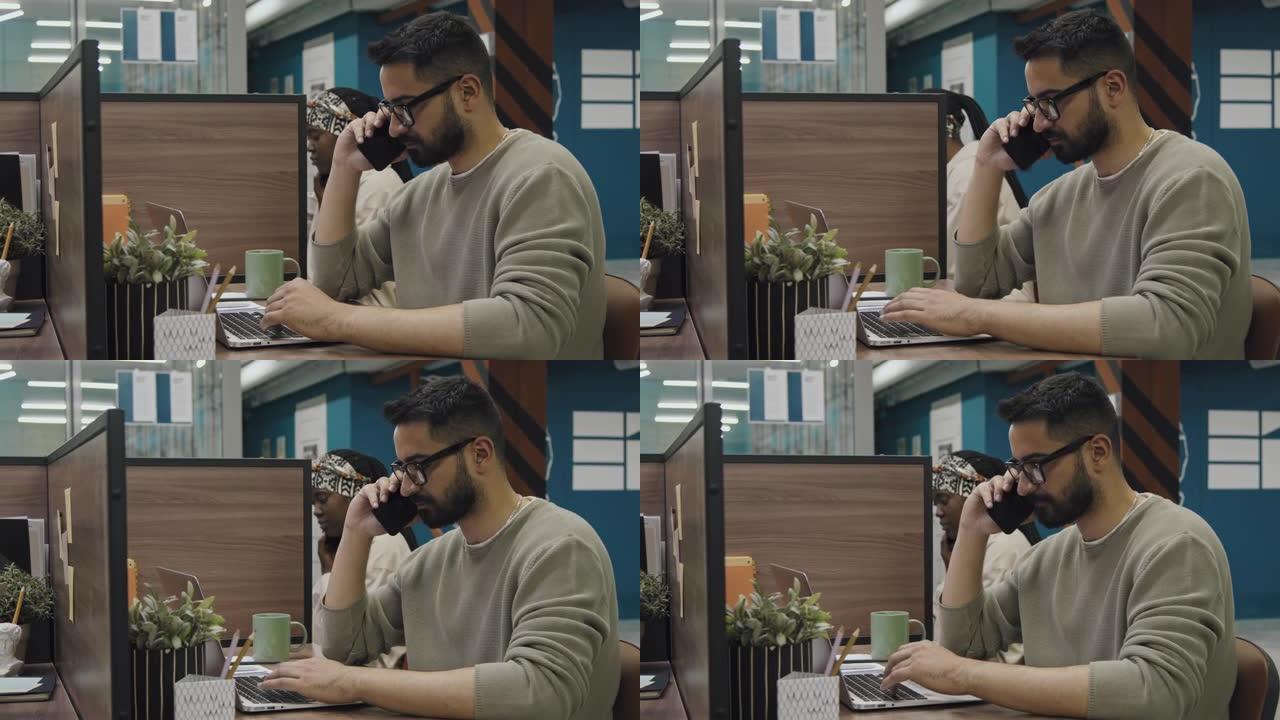 中东男性自由职业者在共享办公室的笔记本电脑上工作