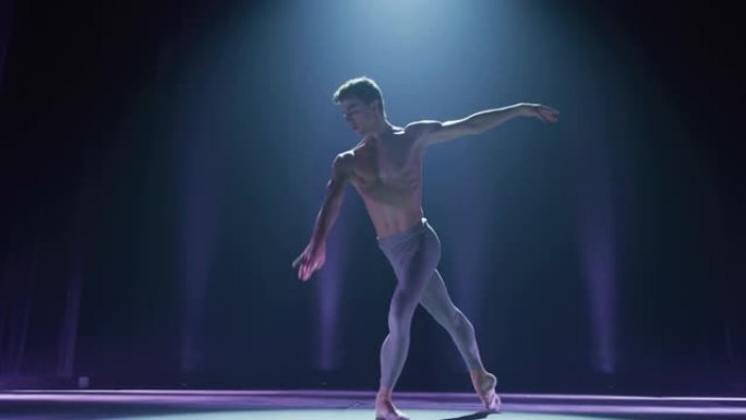 年轻优雅的古典芭蕾舞男舞者在剧院舞台上表演的电影镜头，并带有戏剧性的聚光灯照明。运动男子跳舞并排练舞