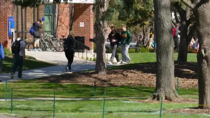 春日凉爽的大学生在繁忙的校园里走来走去