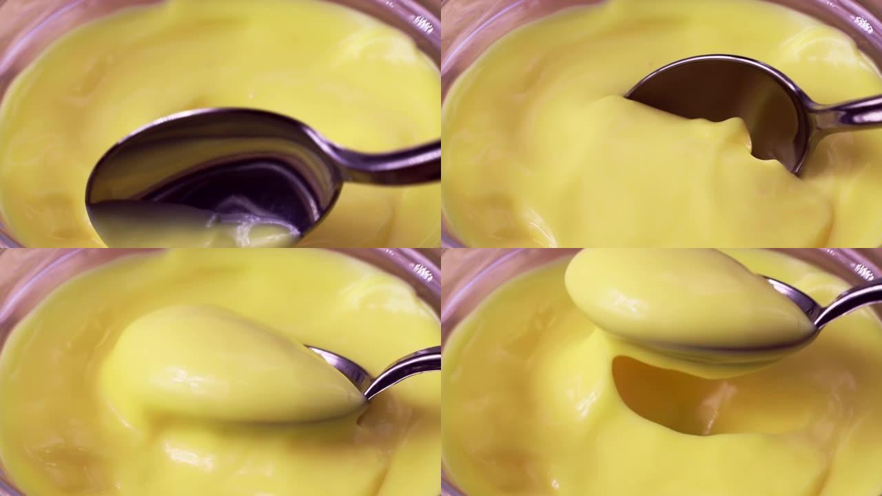 勺子里鲜黄色自制奶酪酱特写