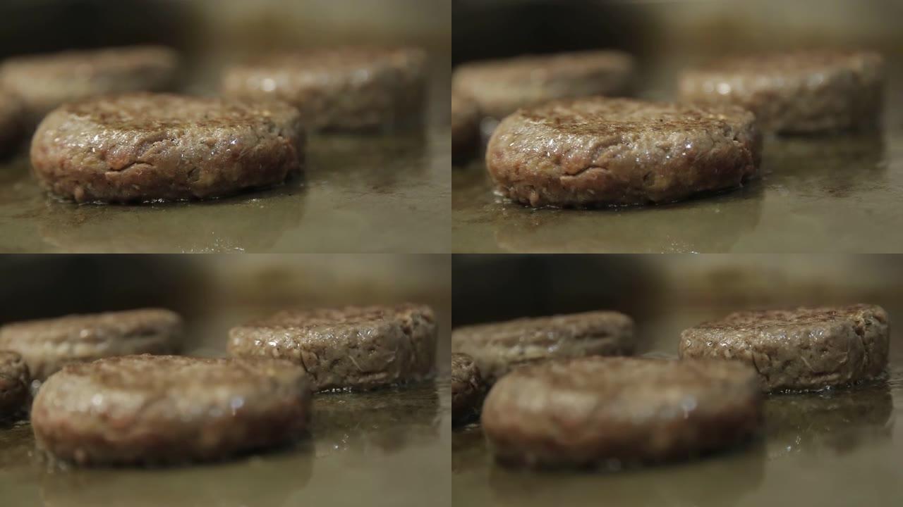 肉饼-在煎锅上近距离烹饪牛肉馅饼-侧面角度-焦点拉力
