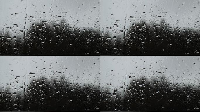 雨天雨滴在玻璃窗上。水滴在玻璃上滑动