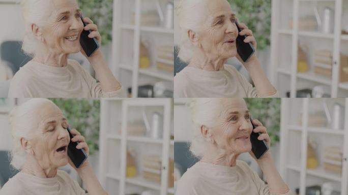 开朗的高级女性在手机上讲话的肖像在家中享受室内对话