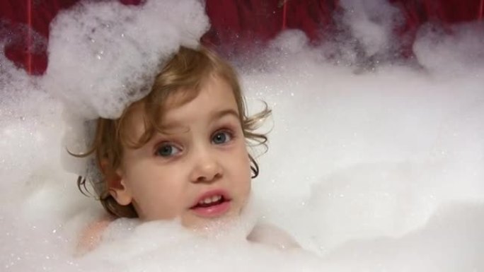 小女孩在浴缸里说话，头上有泡沫