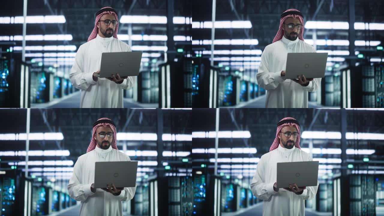 中东数据中心管理员的肖像穿着传统的白色衣服，在现代技术服务器农场设施中使用笔记本电脑。工作中的阿拉伯