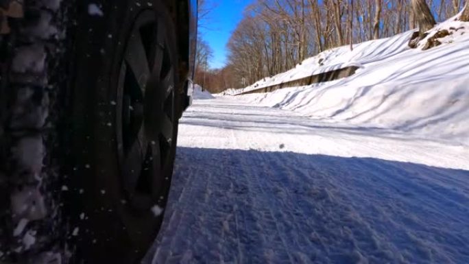 使用冬季轮胎在森林的积雪道路上行驶