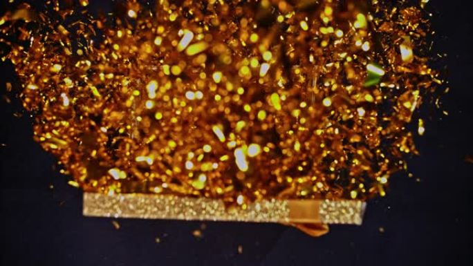 SLO MO LD闪闪发光的金色盒子开口和闪亮的金色五彩纸屑飞向空中