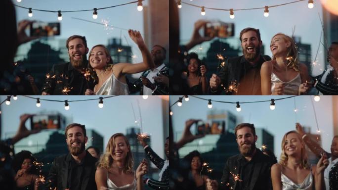 迷人的朋友跳舞与烟火庆祝新年前夜在屋顶派对穿着时尚时尚的朋友使用智能手机分享庆祝视频在社交媒体4k