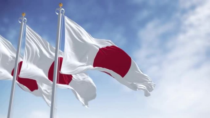 在一个晴朗的日子里，三面日本国旗在风中飘扬的慢镜头