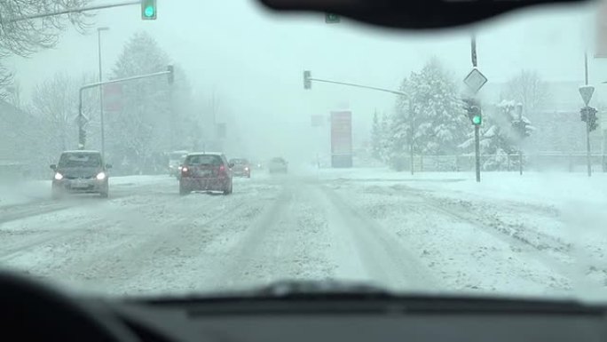 当驾驶员靠近十字路口时，正在下雪