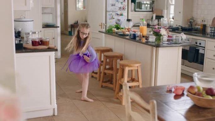 快乐的芭蕾舞女演员在厨房跳舞，在家穿着紫色短裙练习芭蕾舞动作很开心