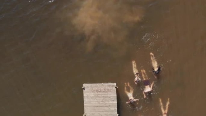 鸟瞰图的朋友在湖里游泳，在水中嬉戏，享受暑假从上面俯瞰无人机