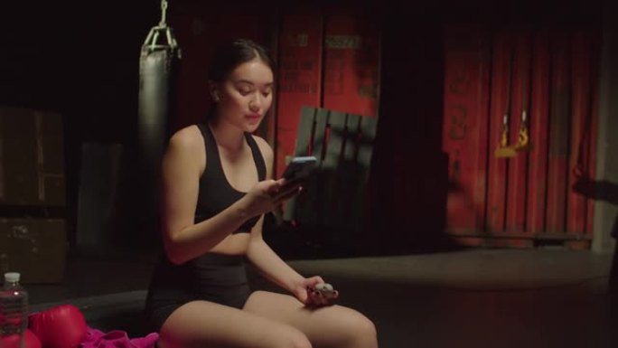 有动力的健身亚洲女性在锻炼前在智能手机上设置音乐