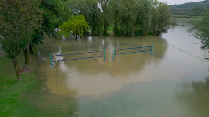 空中: 河边公园的排球场被浑浊的洪水淹没