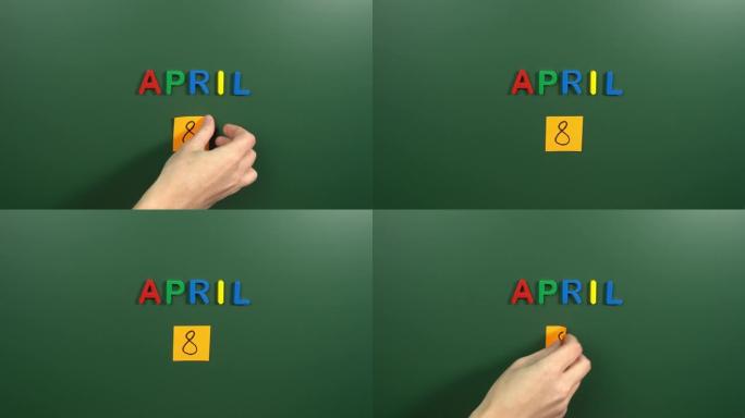 4月8日日历日用手在学校董事会上贴一张贴纸。8 4月日期。4月的第八天。第8个日期号。8天日历。八次