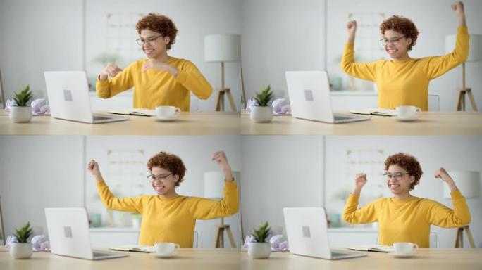 女人看着家庭办公室的笔记本电脑屏幕，阅读或看到好消息，开始挥手，笑着笑，露出幸福的笑容。在工作中晋升