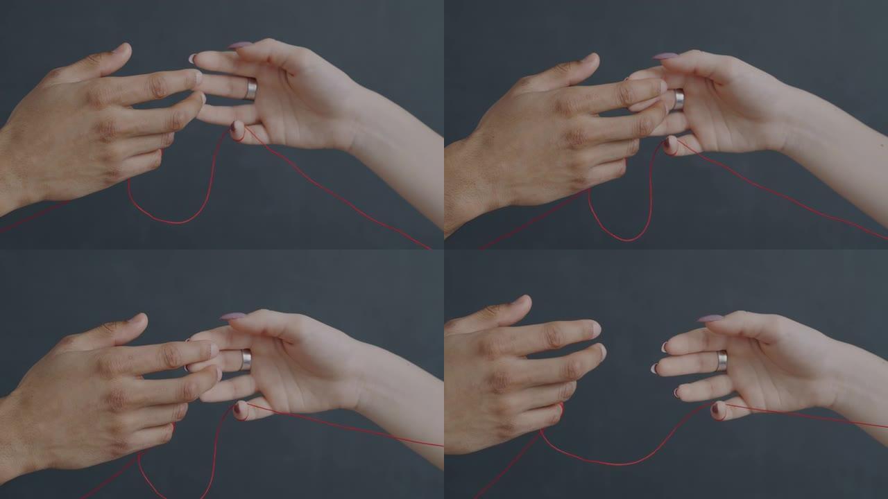 两只手绑着红色的弦触摸手指表达爱情享受灰色背景上的浪漫感觉