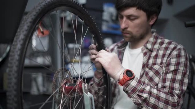 自行车车间的车轮矫直支架。机械师使用工具张紧速飞车边缘的辐条。小型企业自行车维修和服务主题。修整周期