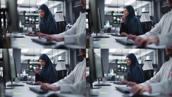 一位体贴的中东女性在一家科技公司办公室的电脑上工作的肖像。年轻女子为创新的互联网和软件服务项目编写软