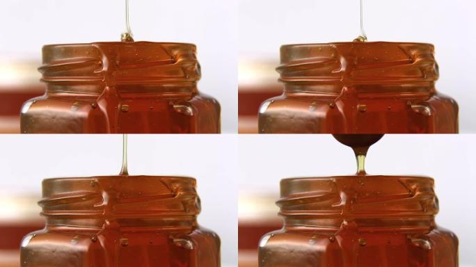 蜂蜜一股金色的蜂蜜流入罐子里。