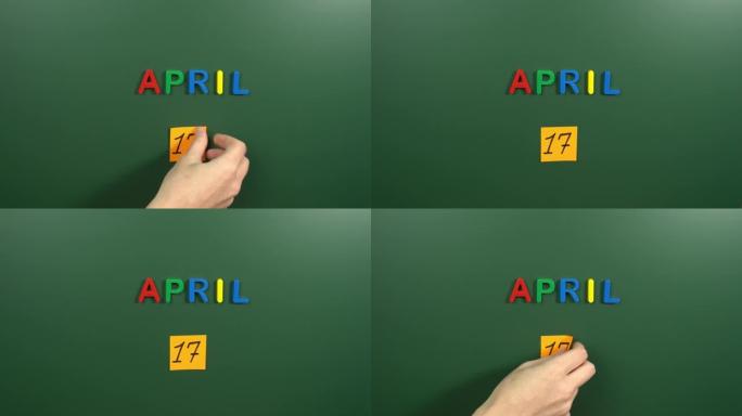 4月17日日历日用手在学校董事会上贴一张贴纸。17 4月日期。4月的第十七天。第17个日期编号。17