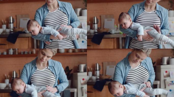 年轻的母亲在家和婴儿跳舞，轻轻地让婴儿平静下来，享受在妈妈怀里放松的俏皮舞蹈