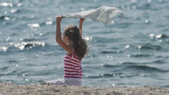 Slow-Mo: 女孩在海边顶风拿着丝巾