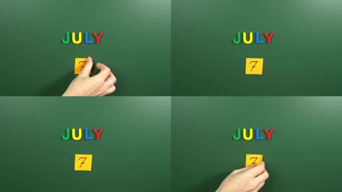 7月7日日历日用手在学校董事会上贴一张贴纸。7 7月日期。7月的第七天。第7个日期号。7天日历。七次