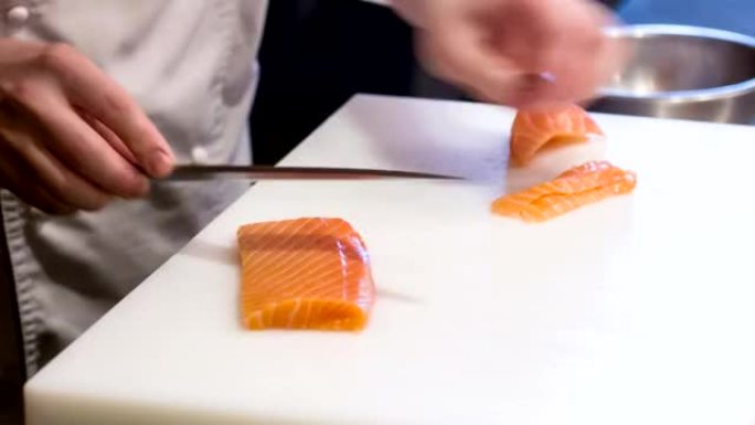 厨师在餐厅厨房切鲑鱼的水平多莉镜头