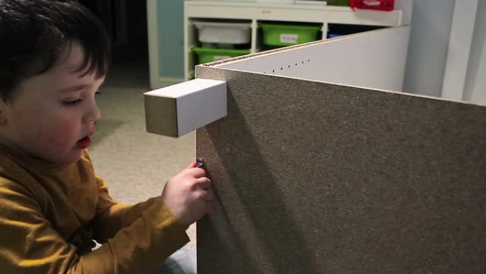 小男孩建造一个自组装的衣柜