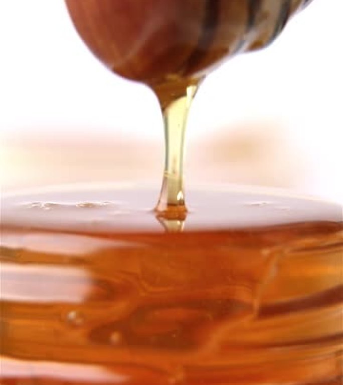蜂蜜一股金色的蜂蜜流入罐子里。