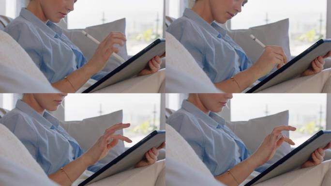 迷人的年轻女子使用数字平板电脑在家工作，用手写笔浏览电子邮件，享受移动设备技术