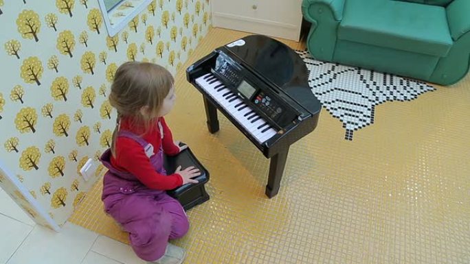 女孩在玩具钢琴上演奏，顶视图