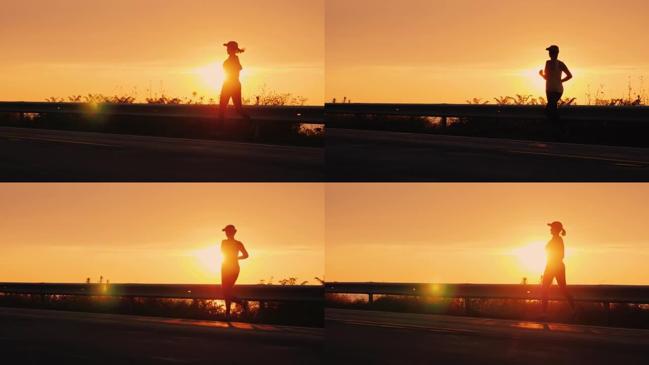 日落时，一名年轻活跃女子在海边的一条路上慢跑的剪影