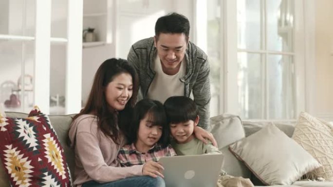 亚洲夫妇和孩子在家里一起使用笔记本电脑