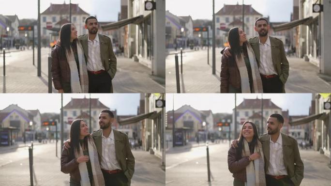 幸福的夫妇在城市街道人行道上向前走。追踪一名阿拉伯中东男人和女人一起运动的镜头