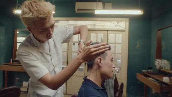 亚洲理发师在客户头发上使用定型粉