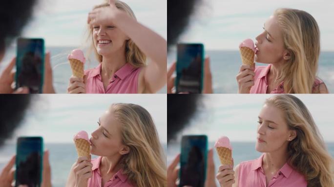 美丽的金发女人，非洲在海滩上吃冰淇淋，为朋友拍照，使用智能手机女孩朋友在社交媒体上分享快乐的夏日4k