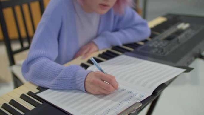 合成器的女作曲家特写，将音符写成乐谱