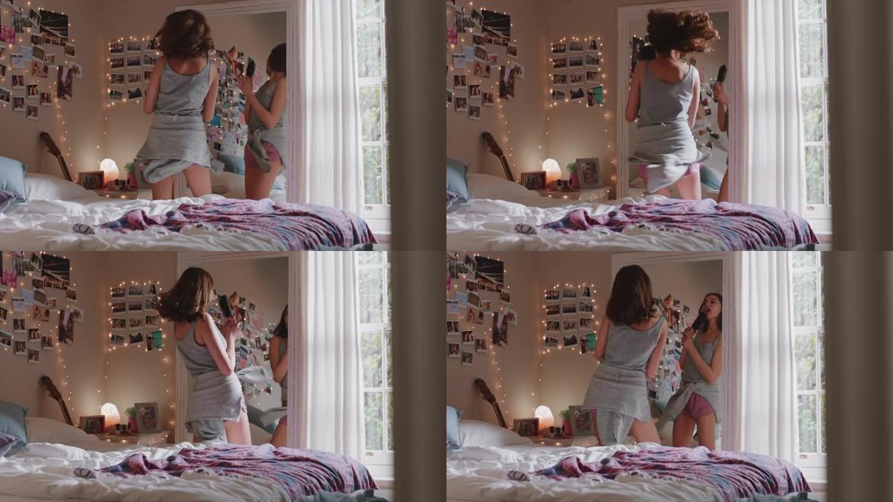 快乐的少女在卧室跳舞享受音乐庆祝周末快乐的青少年生活中穿着睡衣在家唱歌