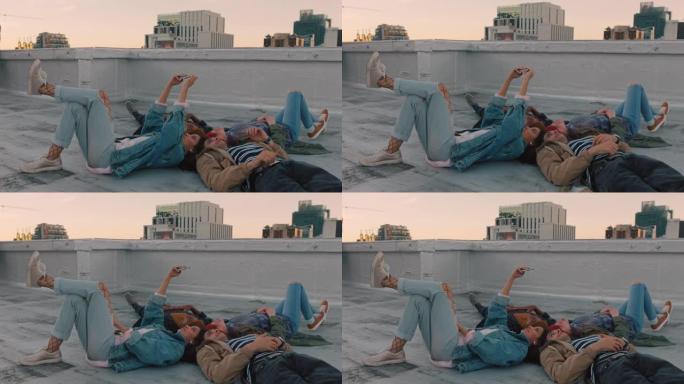 快乐的朋友躺在屋顶上闲逛，使用智能手机相机拍摄自拍照片，一起享受共享周末