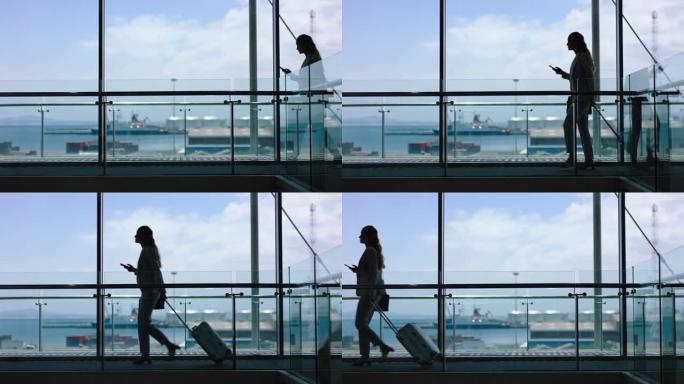 商务女性带着拉杆包行走，使用智能手机在机场大堂进行国际商务旅行，可以看到港口4k镜头