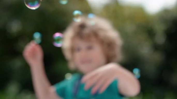 可爱的小男孩顽皮地捕捉肥皂泡漂浮着快乐的孩子在阳光明媚的公园无忧无虑的童年游戏4k