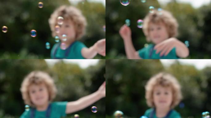 可爱的小男孩顽皮地捕捉肥皂泡漂浮着快乐的孩子在阳光明媚的公园无忧无虑的童年游戏4k