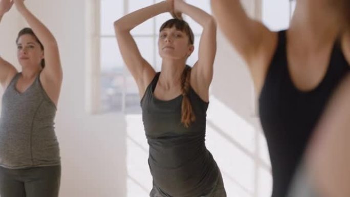 肖像年轻怀孕的白人妇女在瑜伽课上锻炼健康的生活方式练习站立向前弯曲姿势冥想享受团体体能锻炼