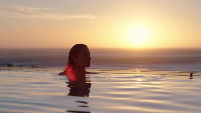 女人在豪华酒店水疗中心的游泳池里放松，享受美丽的日落海景地中海旅游度假胜地4k