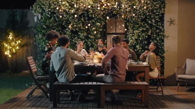 一群朋友庆祝晚宴分享自制餐享受休闲交谈周末聚会放松在平静的夏夜户外4k镜头