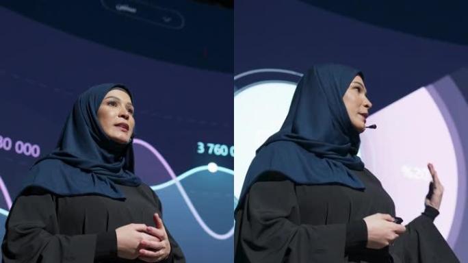 垂直屏幕: 成功的中东女性演讲者展示了新产品，在大屏幕上显示了信息图表，统计动画。在新闻发布会上谈论